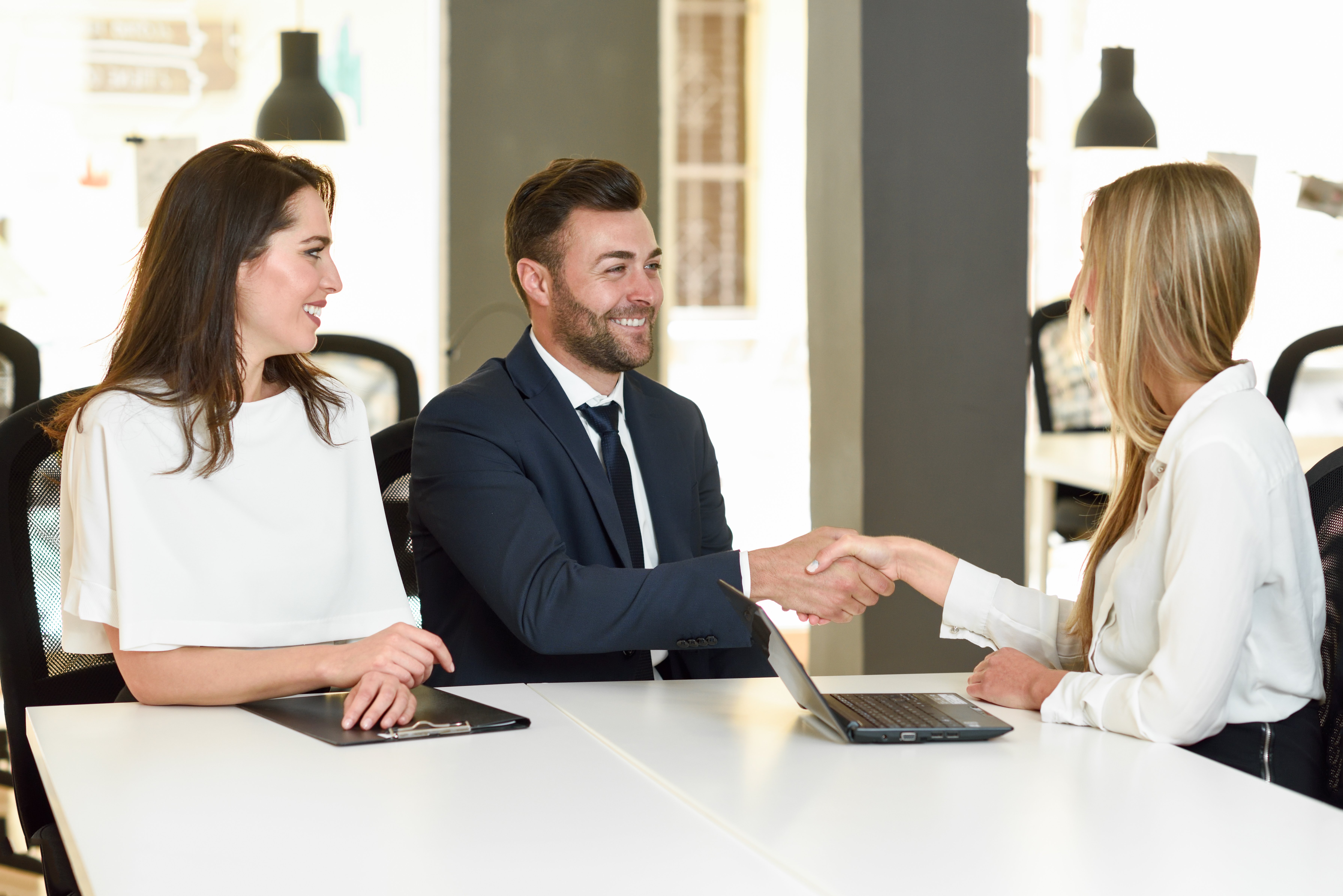 smiling-young-couple-shaking-hands-with-insurance-agent